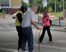 Image of person helping an elderly person cross the street