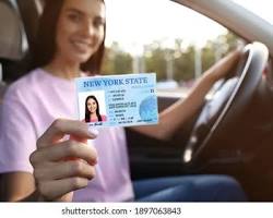 Image of someone happily holding a new driver's license