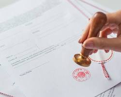 Image of person signing a document with a notary