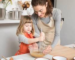 Image of Parent helping child stir soup