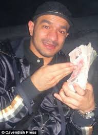 Mohammed Basit Chaudhry clutches a wad of bank notes in a photo taken while he was - article-2554110-1B45F01C00000578-604_306x423