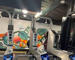 Image of person struggling with a MetroCard machine in a New York City subway station