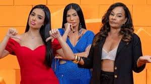 Três mulheres posam para foto com expressões faciais distintas. Uma de vermelho faz sinal de 'não', a do meio de azul pensa …