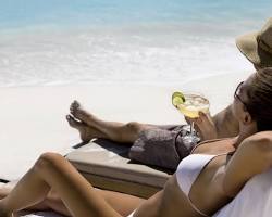 Image of teacher relaxing on a beach with a margarita