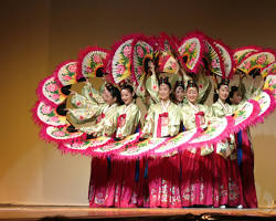 Korean folk dancers performing Buchaechum (Fan Dance) – dancers in vibrant costumes with large, colorful fans 이미지