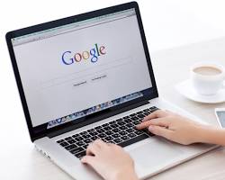 person doing keyword research on a laptop resmi
