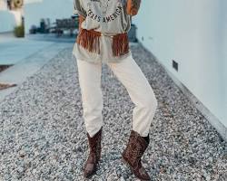 Image of woman wearing jeans, a tshirt, boots, and a hat in Texas