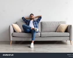 Image of person with a disability happily sitting on their couch in a cozy apartment