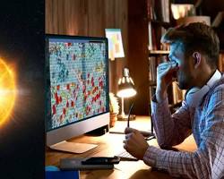 Image of person looking at a computer screen with an eclipse on it