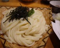 水沢うどん：ざるに盛られたツヤツヤの水沢うどん、天ぷら、つけ汁の画像