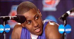 Kansas guard Mario Chalmers leans in as he listens to teammate Sasha Kaun answer questions . - KU_chalmers_presser_t960