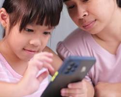 Image of Family laughing while using smartphones for mobile banking