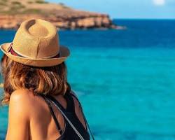 Image of person wearing sunglasses and looking relaxed on a beach, with a globe in the background
