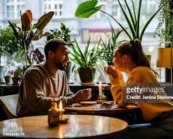 Image of two people playfully flirting at a café