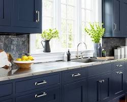 Image of kitchen with blue cabinets, white countertops, and stainless steel appliances