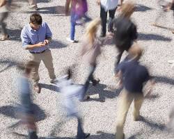 Image of person searching for a doctor on their phone in a busy NYC street