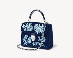 Image of navy blue leather clutch with delicate floral embroidery