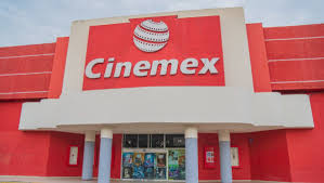 Cinemex: Sala de cine vac&iacute;a con butacas rojas y pantalla iluminada