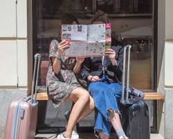 Image of person sitting on a hospital bench with a suitcase