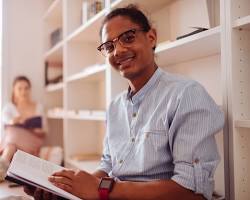 Image of person reading a book with a satisfied smile on their face