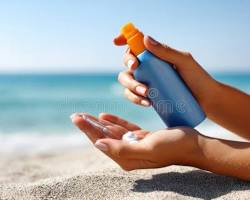 person applying sunscreen on a sunny beachの画像
