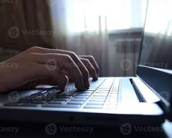 Image de person writing on a laptop at home