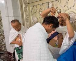 صورة person shaving their head or cutting their hair during Umrah