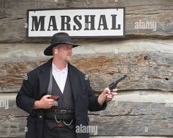 Image of Bat Masterson, a seasoned lawman with a stern expression, wearing a cowboy hat and a long coat, holding a revolver