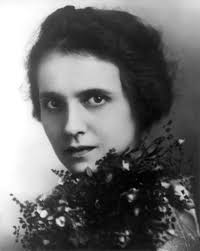 Black and white studio photo of Elizabeth Burbank, head and shoulders, with head turned and holding flowers over her shoulder. - image081