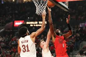 Portland Trail Blazers forward Jerami Grant, right, drives to the basket beside Cleveland Cavaliers forward Dean Wade, center, and center Jarrett Allen, right, during the first half of Sunday\'s game in Portland.