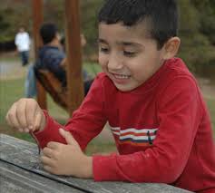 Sebastian brings a worm to put on his new hook. It was easy to find worms by digging around the area. - 78sebworm