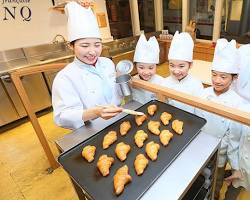 children learning how to bake bread at a bakery in Kidzania Fukuoka.の画像