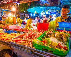 Gambar bustling night market in Solo, filled with food stalls and people enjoying various dishes.