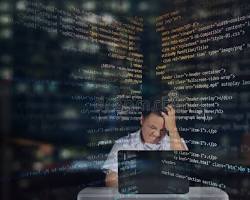 Image of student typing furiously on a laptop, surrounded by code