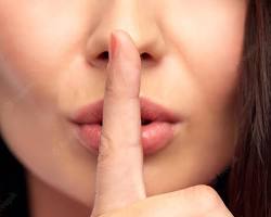 Image of person holding up a finger to their lips