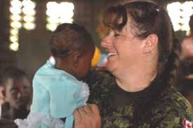 Corporal Eva-Marie Rogerson, assigned to USS Kearsarge, spends a bit of time with a child in a village where the medical needs of the local - rogerson-e