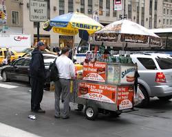 Image of tourist eating a hot dog from a street vendor in New York City