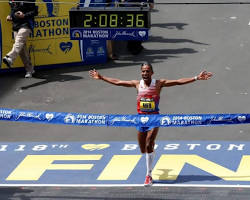 Image of person running a marathon, focused on the finish line