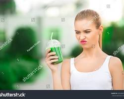 Image of someone making a disgusted face while drinking water