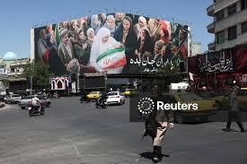 Licensable picture: People walk past a billboard with a picture of Iranian people, in Tehran