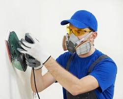 Image of painter wearing safety gear while painting a high ceiling