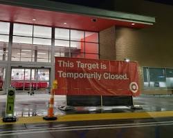 Image of person looking sadly at a closed CVS store