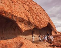 tourists and visitors standing at the base of Uluru