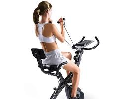 person happily riding a MaxKare Exercise Bike at home