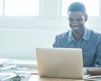 Image of person sitting at a desk with a computer and a list of things to do