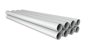 PVC pipes stacked in warehouse. A series of white tubes on ...