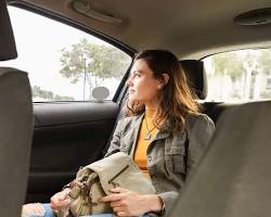 Image of passenger sitting in back seat with seatbelt on looking aware