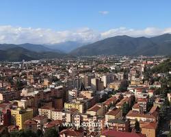 Immagine di Panorama di una città italiana con industrie e chiese, a simboleggiare l'unione di industria e cultura