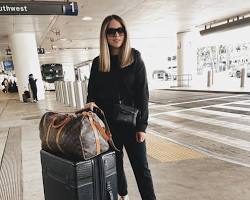 Image of teacher holding a suitcase and a plane ticket