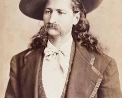 Image of Wild Bill Hickok, a legendary figure of the American West, with a stern expression on his face, holding a Colt revolver